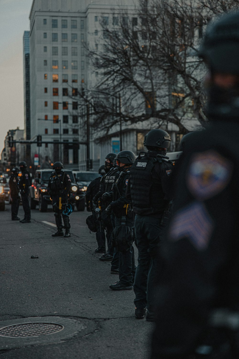 people in black uniform walking on street during daytime