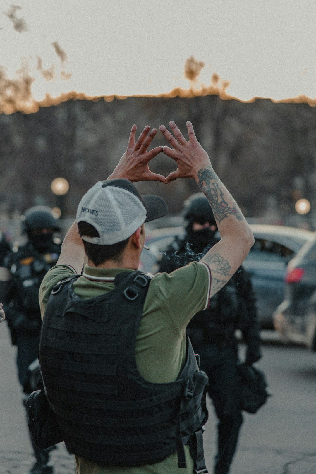 man in green jacket raising his hands