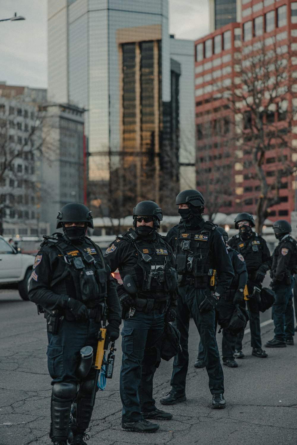 group of men in black and yellow uniform standing on road during daytime