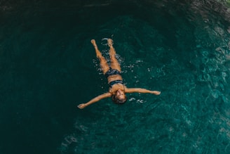 woman in black bikini swimming in water