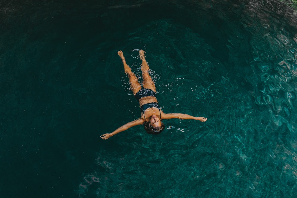 Frau im schwarzen Bikini beim Schwimmen im Wasser