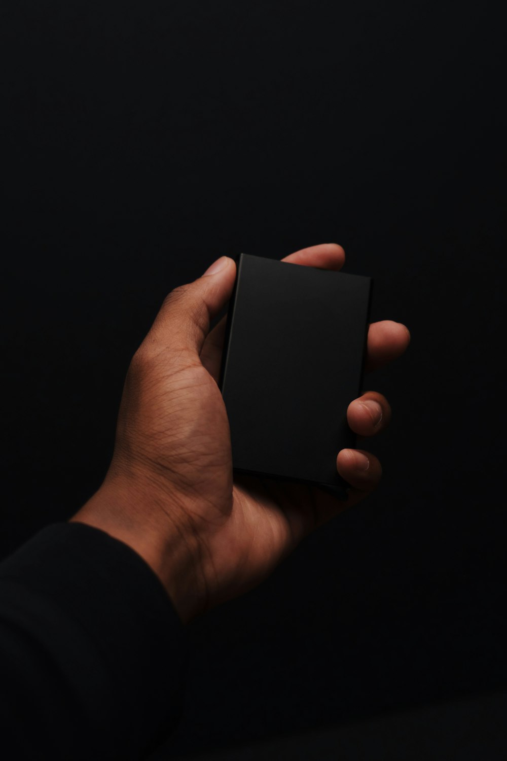 person holding black rectangular device