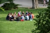 A diverse group of people discussing ideas in a sunny park.