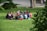 A diverse group of residents discussing community updates in a sunny park.