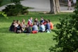 A diverse group of people sitting in a circle engaging in a lively discussion outdoors.