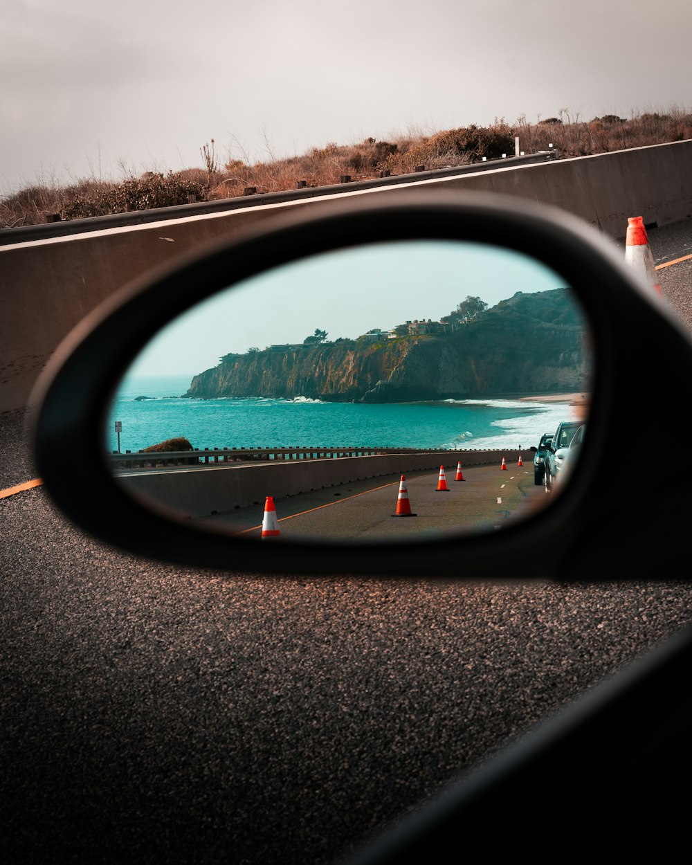 car side mirror reflecting green trees during daytime