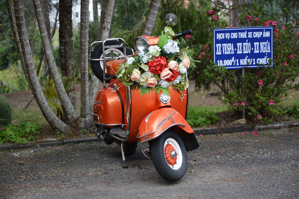 red and black motor scooter with flowers on top