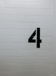 black arrow sign on white brick wall