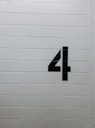 black arrow sign on white brick wall