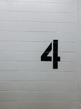 black arrow sign on white brick wall