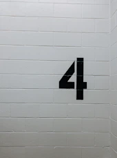 black arrow sign on white brick wall