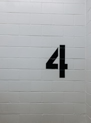 black arrow sign on white brick wall