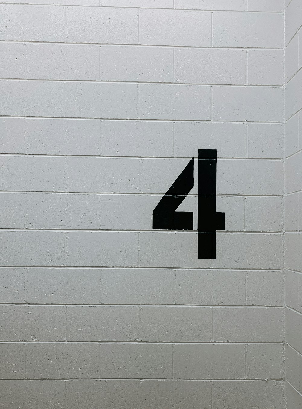 black arrow sign on white brick wall