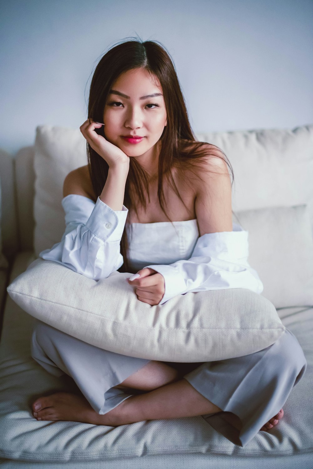 woman in white dress sitting on white couch