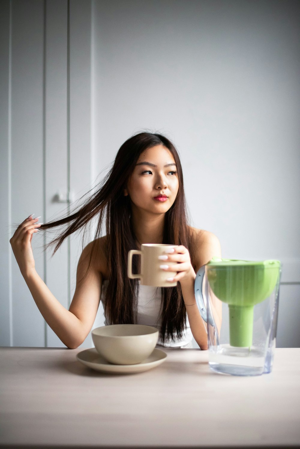 woman holding white ceramic mug