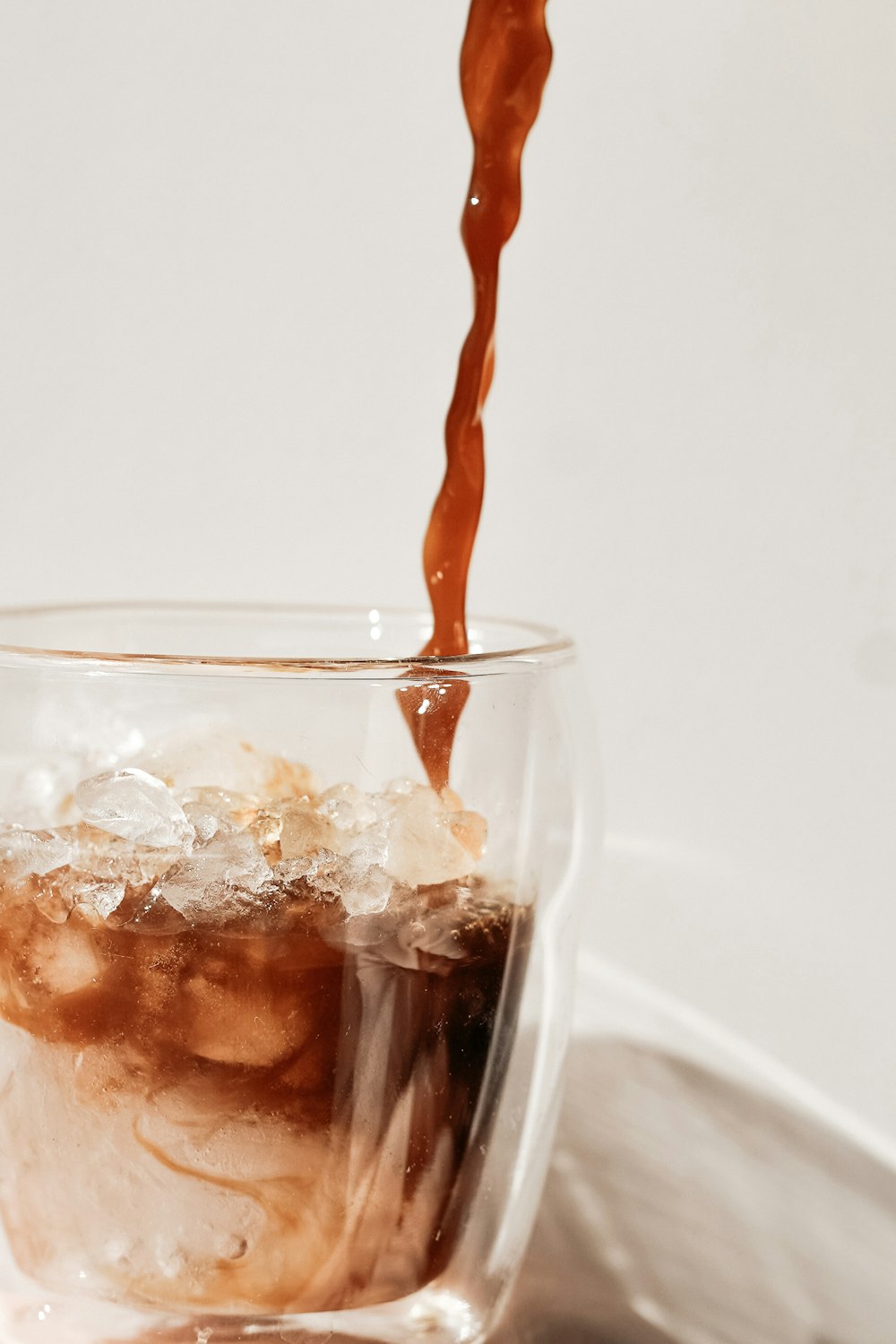 clear drinking glass with brown liquid