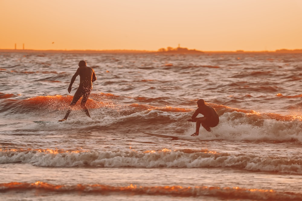 2 men and woman holding hands on beach during sunset