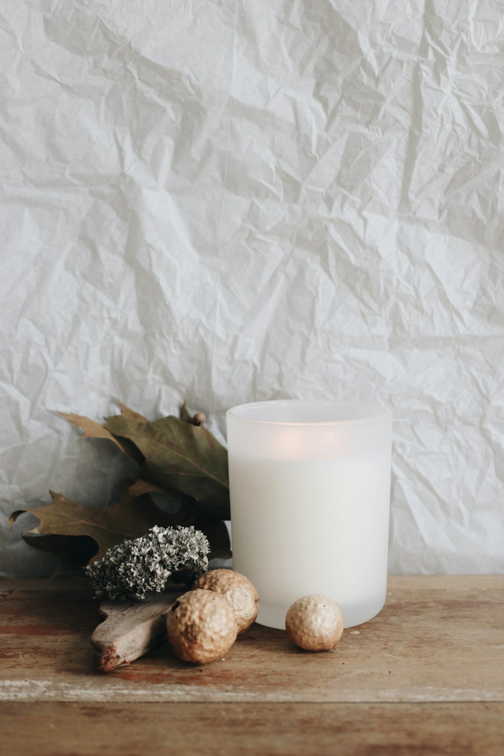 white pillar candle on brown wooden table