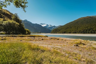 A tranquil landscape of Glacier Park with mountains and lush greenery.