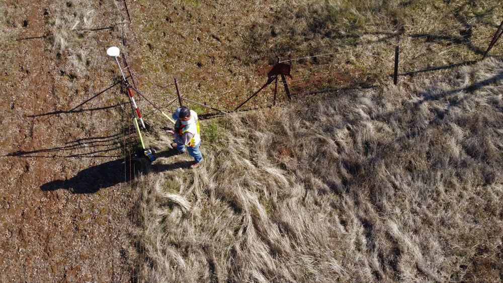 man in blue shirt and blue pants climbing on brown mountain during daytime