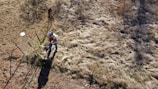 man in blue jacket and black pants climbing on brown rock