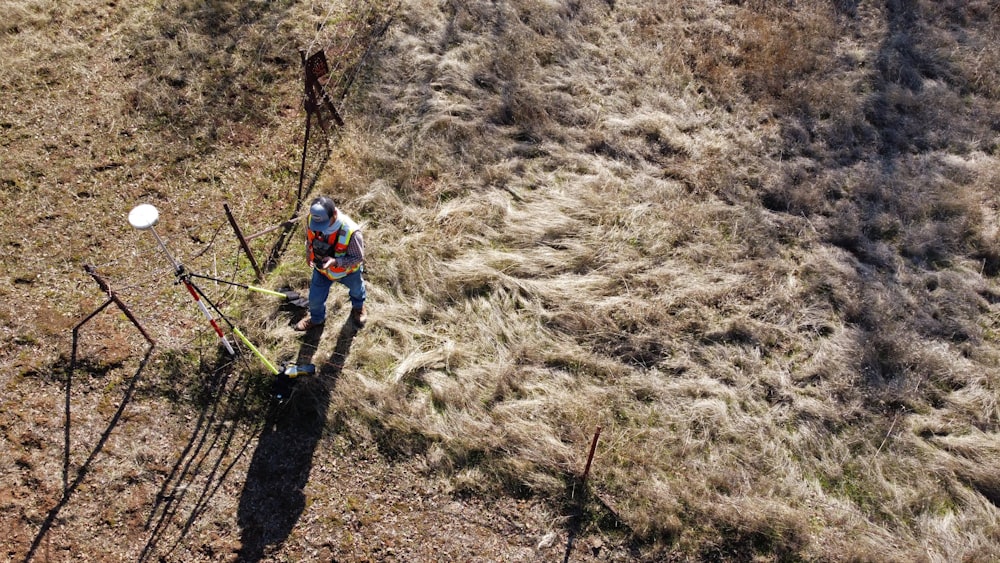 man in blue jacket and black pants climbing on brown rock