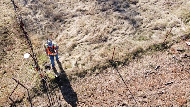 Field worker walking a dirt road between monitoring points