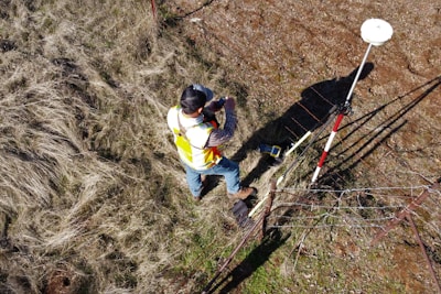 man in yellow shirt and blue denim jeans climbing on ladder during daytime