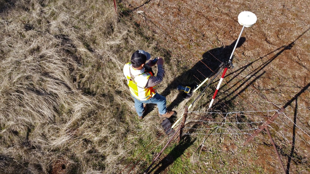 man in yellow shirt and blue denim jeans climbing on ladder during daytime