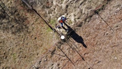 man in black pants and white helmet holding black and white stick