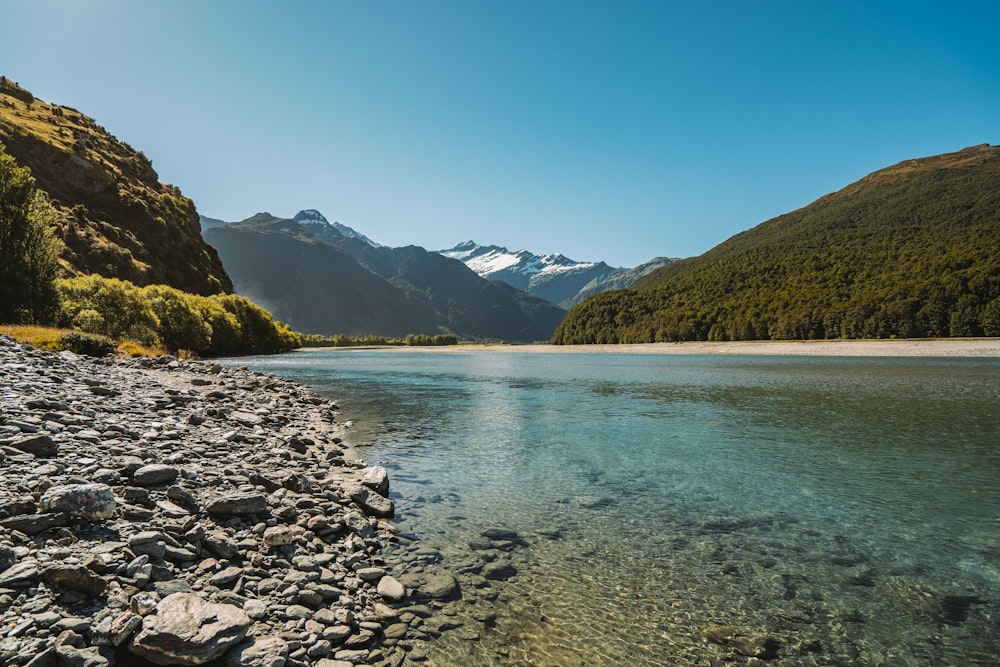 green mountains beside body of water during daytime