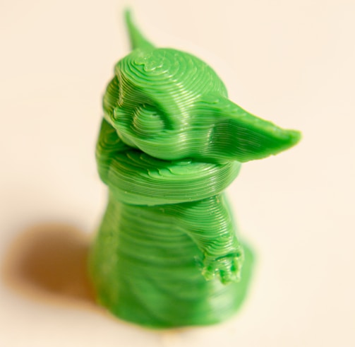 green dragon figurine on white surface