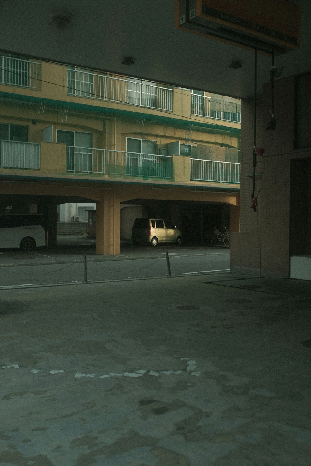 white car parked in front of brown and green concrete building during daytime