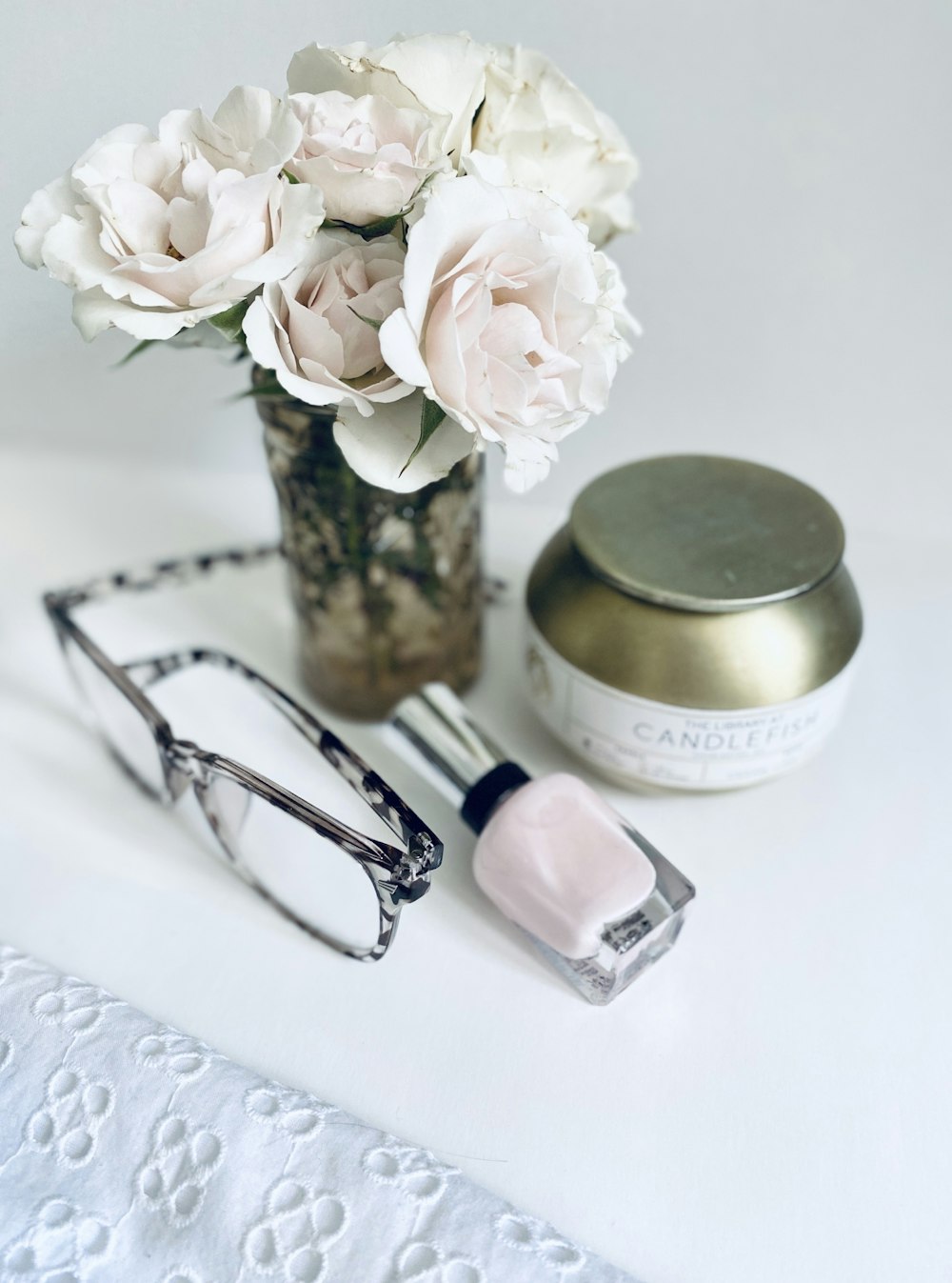 white flowers beside black framed eyeglasses and black framed eyeglasses