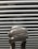 A close-up view of a compact fluorescent light bulb with a spiral shape set against a background of horizontal blinds.
