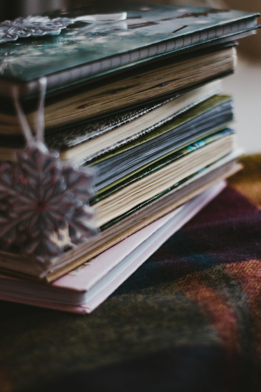 stack of books on brown and red textile