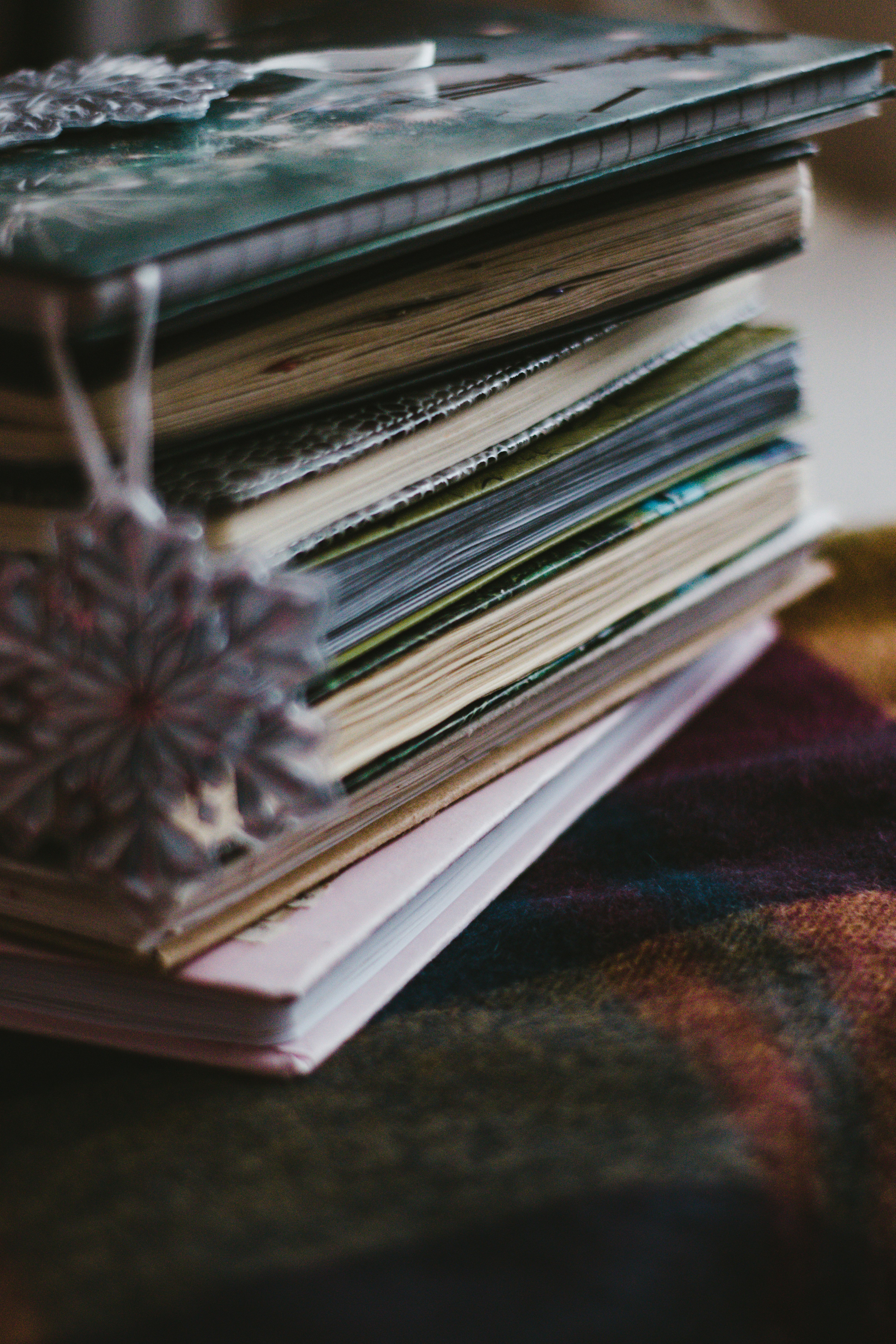 stack of books on brown and red textile