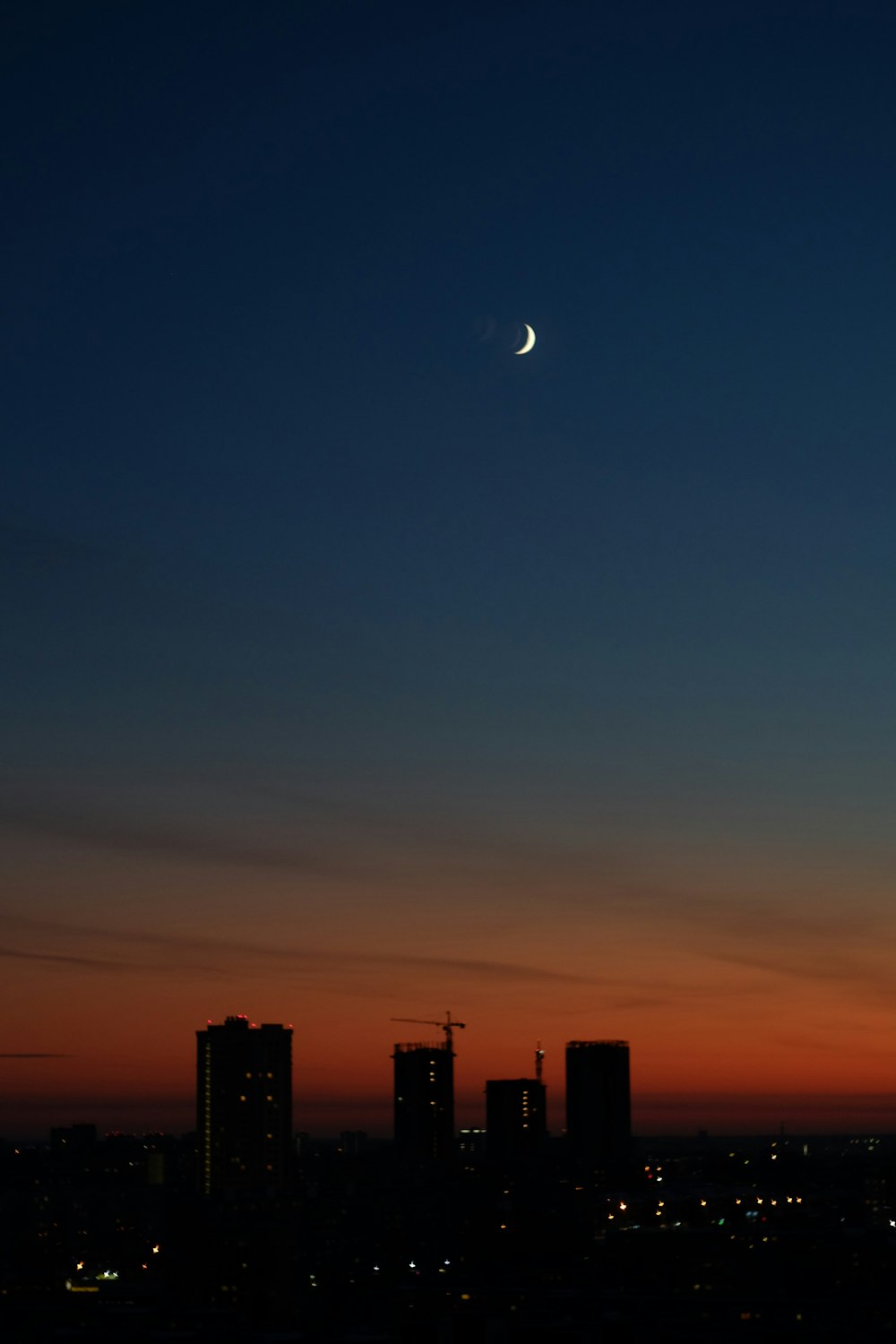 silhouette of city buildings during night time