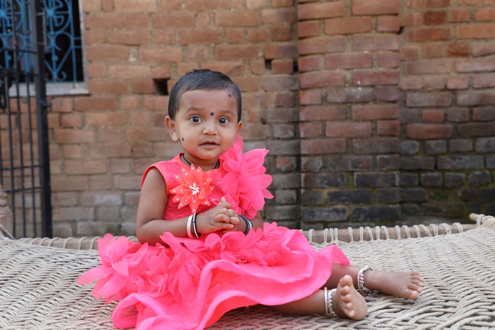 girl in pink tutu dress sitting on brown wooden bench