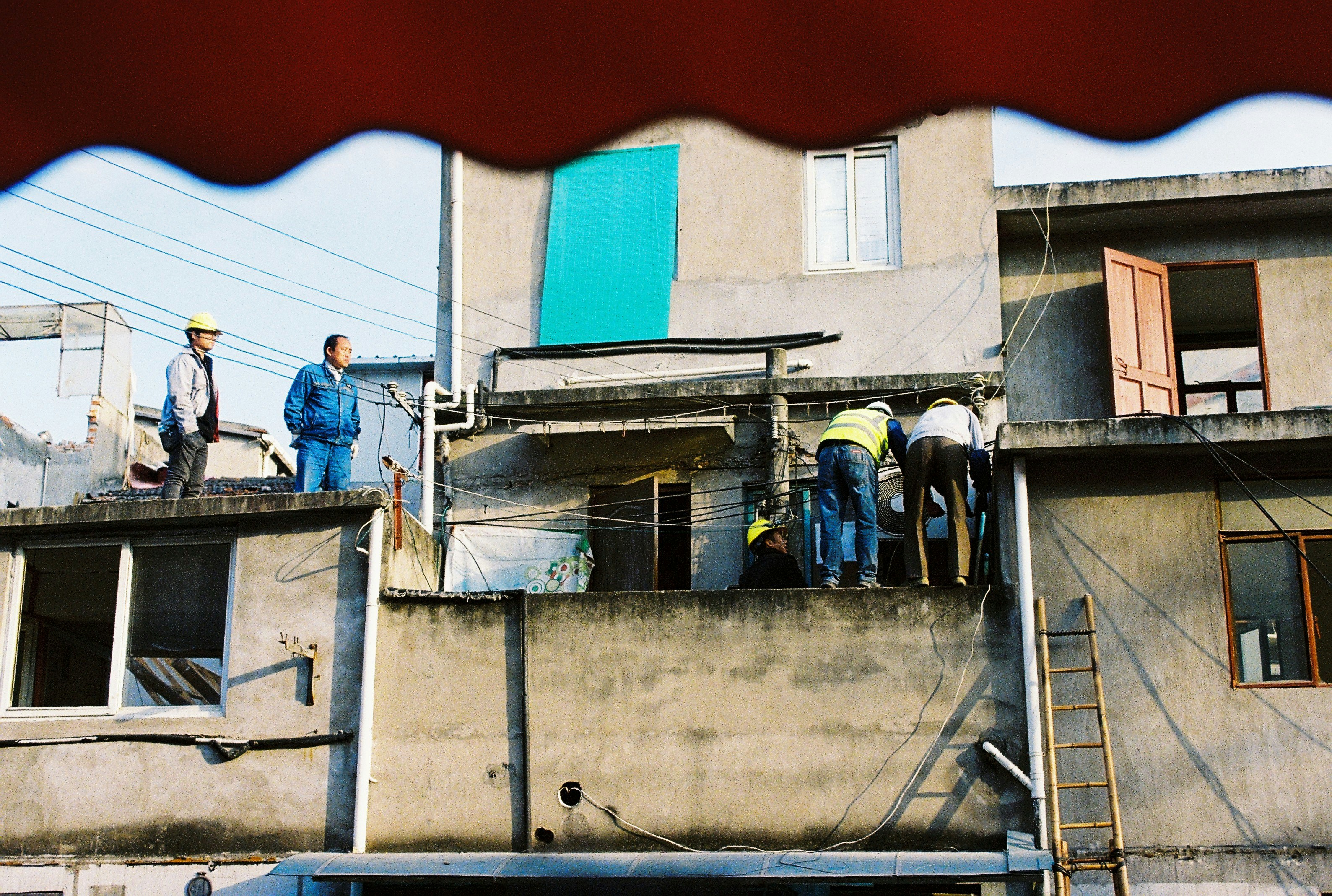 man in blue jacket standing on gray concrete building during daytime