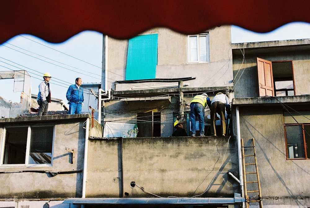 man in blue jacket standing on gray concrete building during daytime