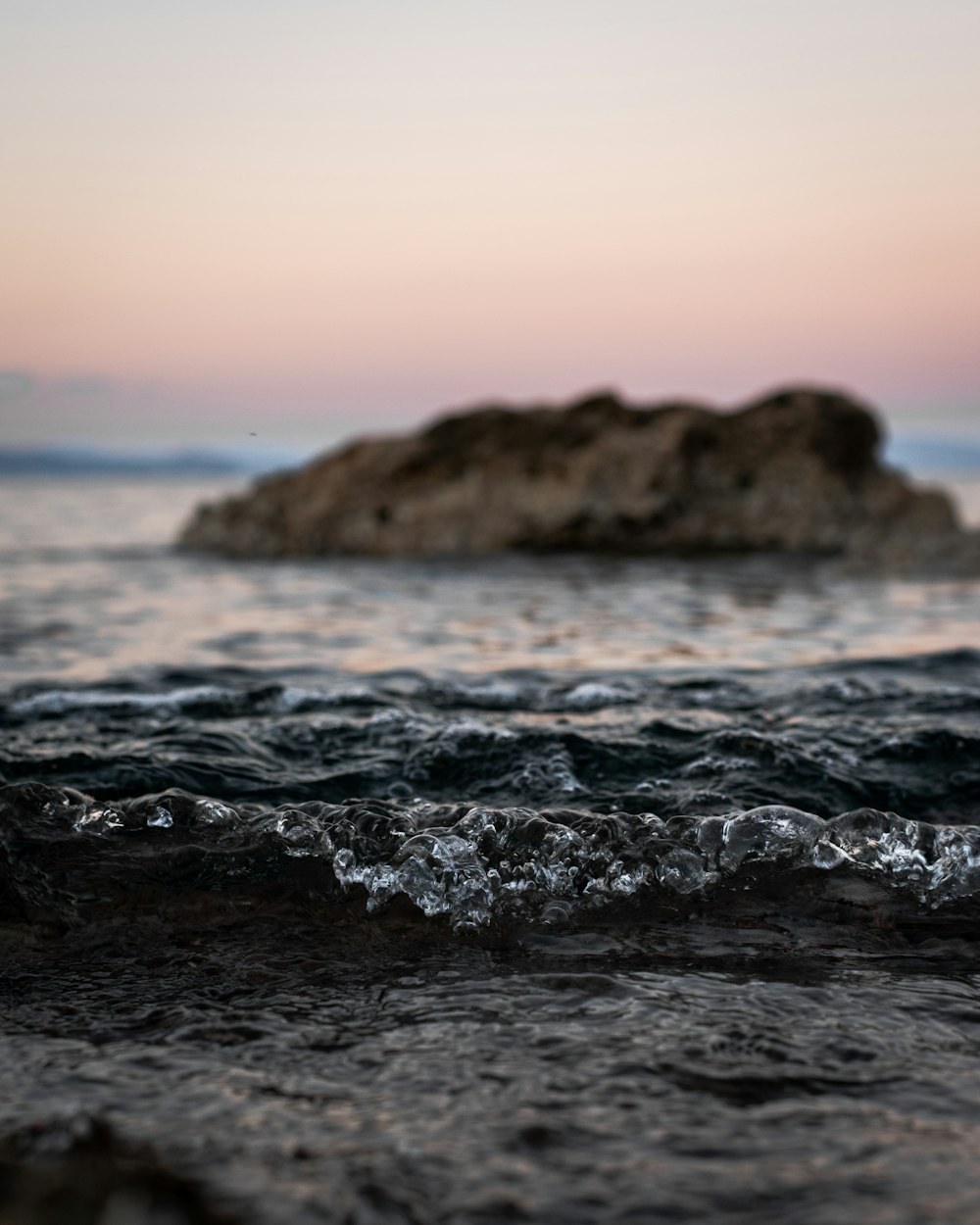 ocean waves crashing on brown rock during daytime