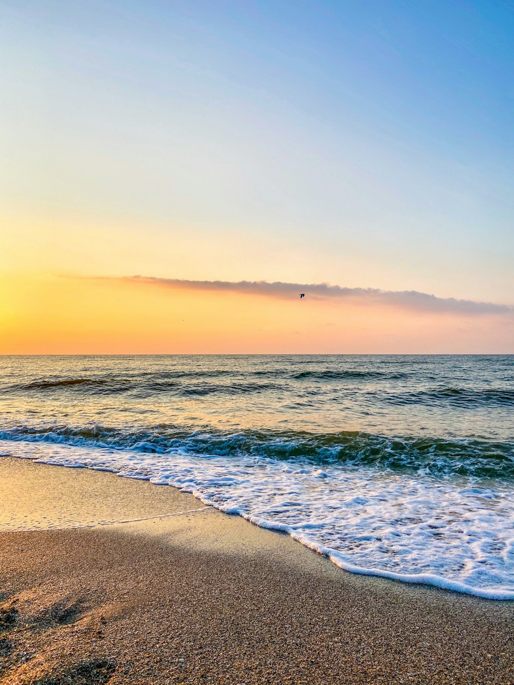 Meereswellen stürzen während des Sonnenuntergangs an Land