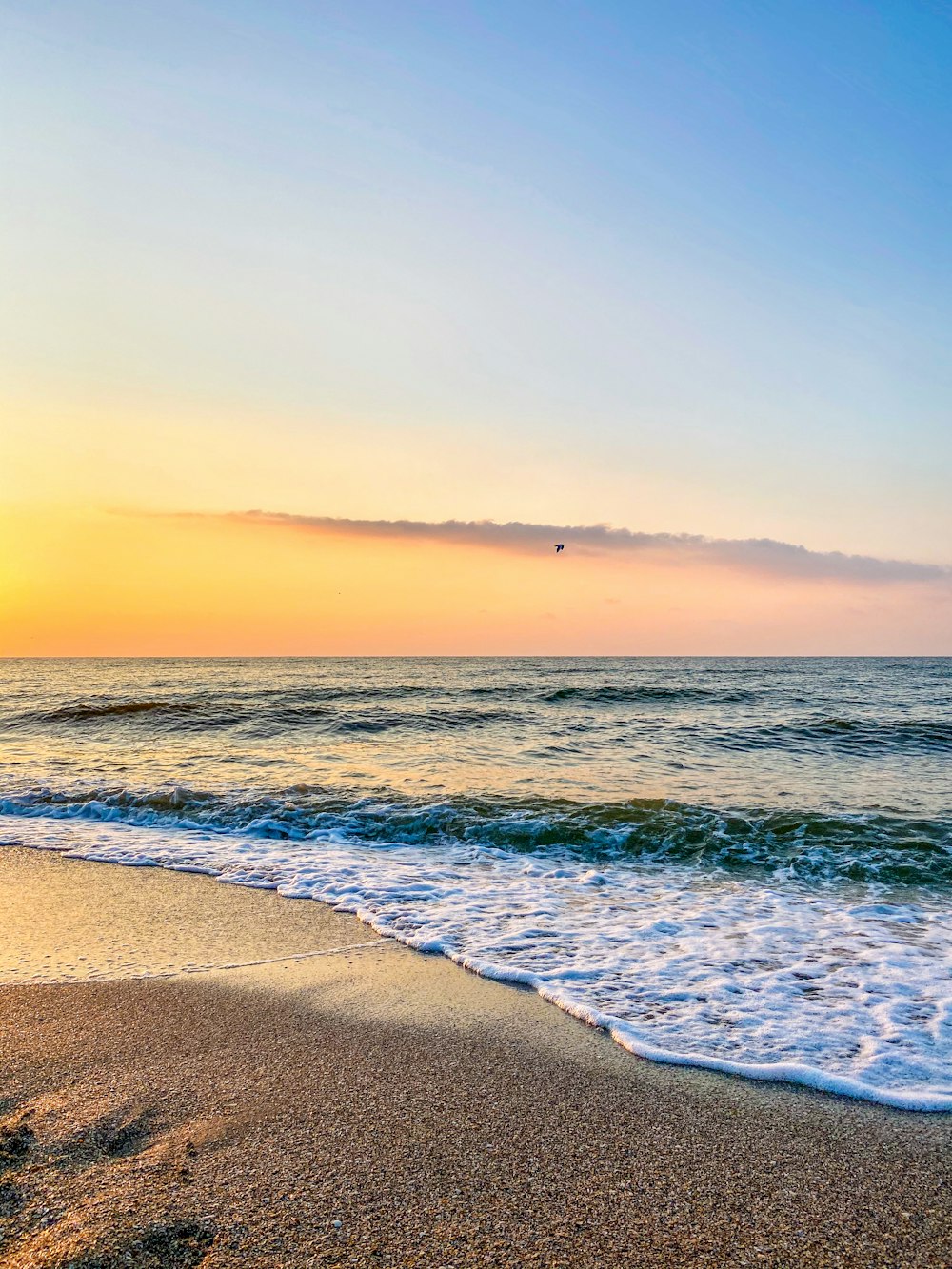 ondas do oceano batendo na costa durante o pôr do sol