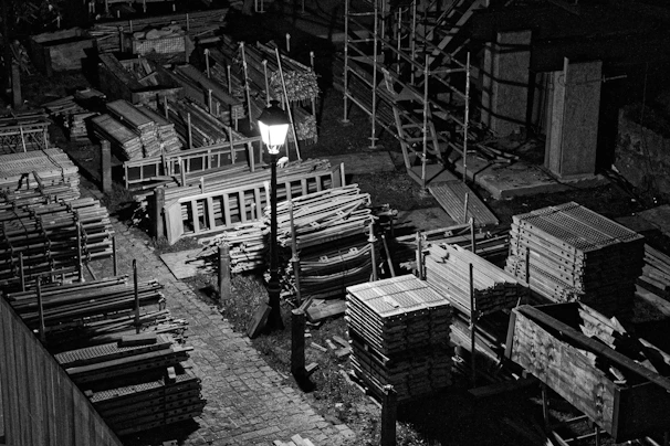 A sleek black and white photo of a modern construction site at dusk, highlighting steel frameworks.