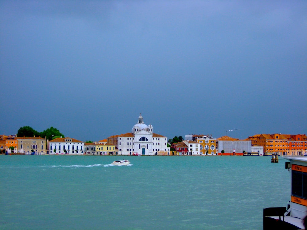 white and brown concrete building near body of water during daytime