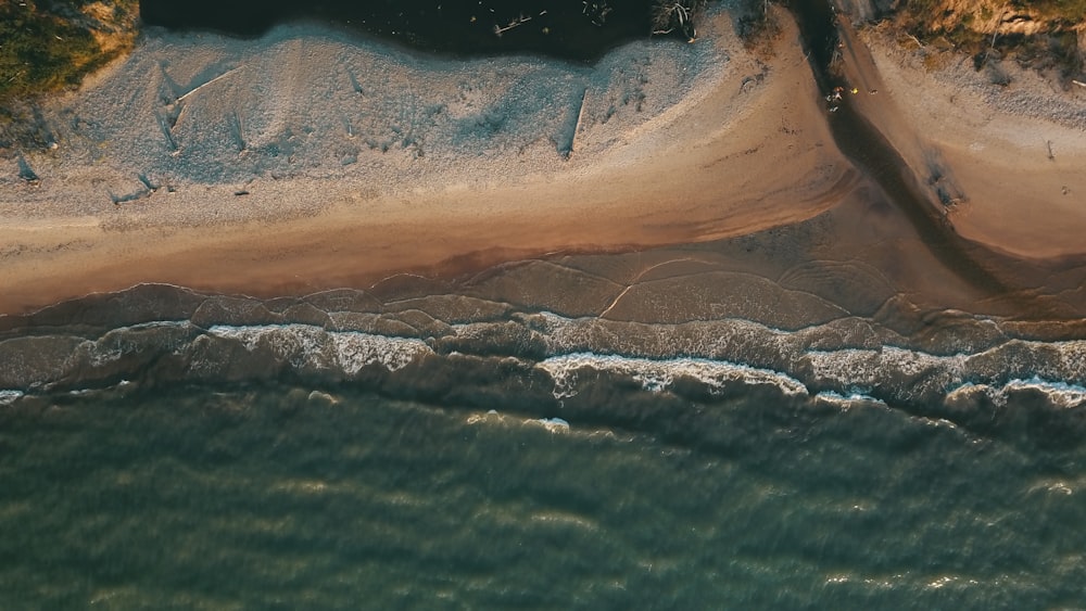 aerial view of ocean waves crashing on shore during daytime