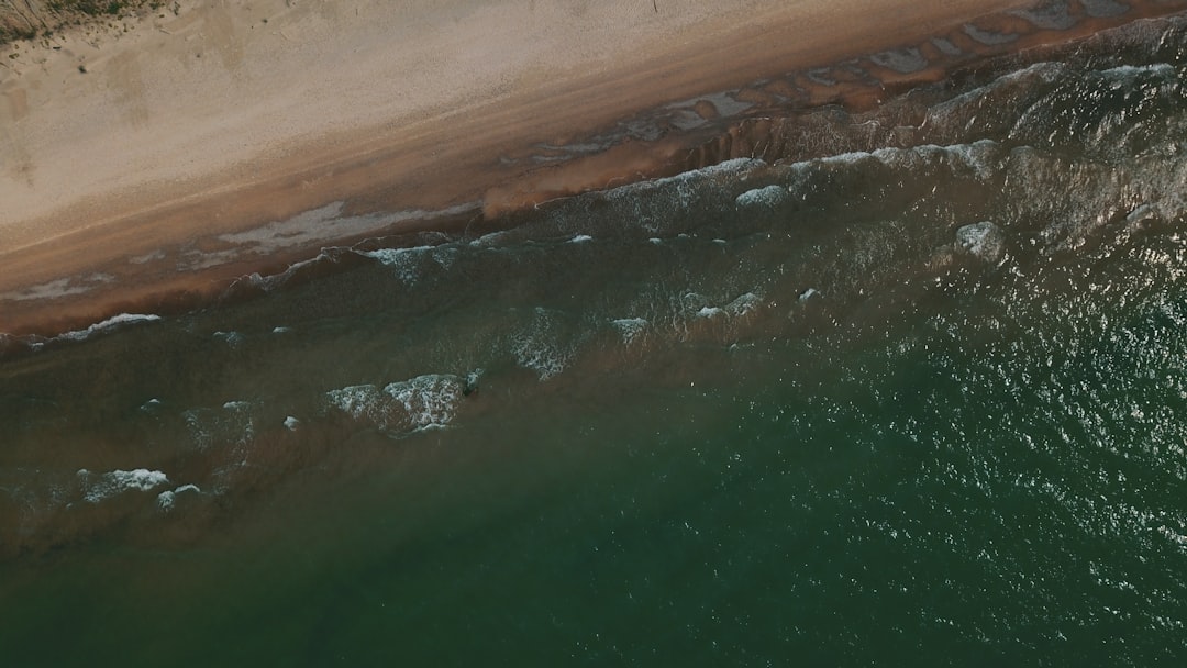 body of water near brown sand during daytime