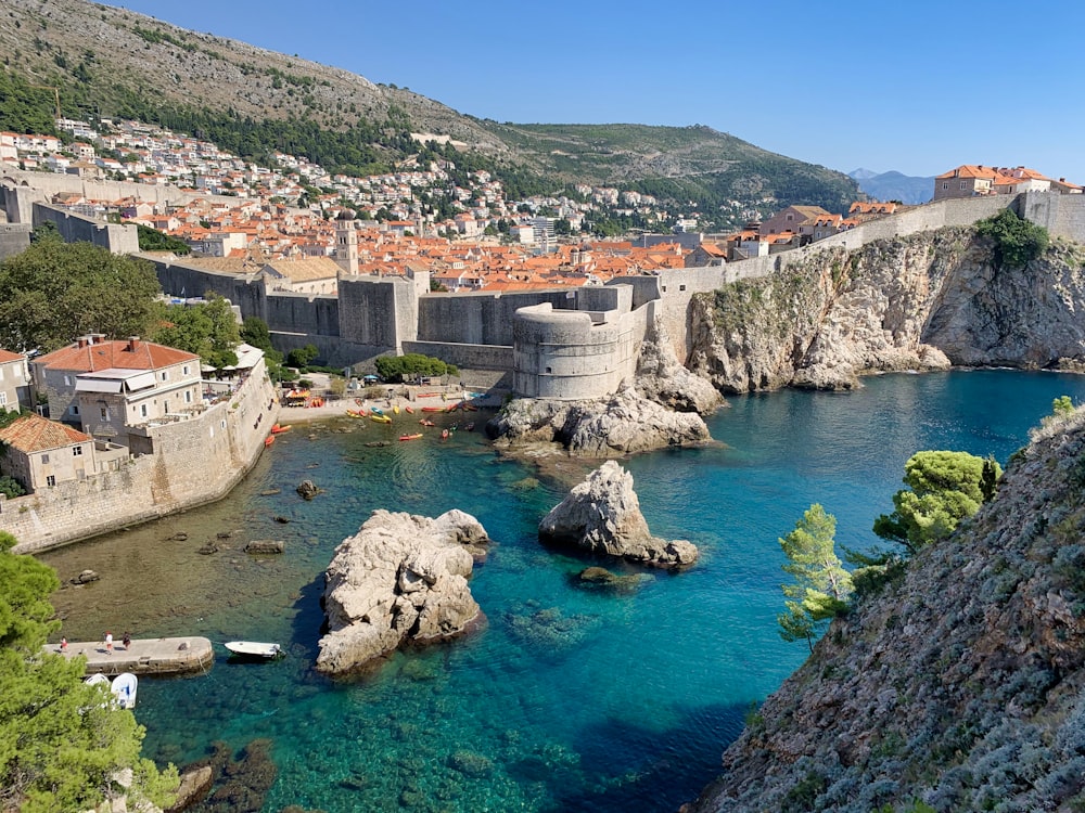 Bâtiment en béton blanc et brun près d’un plan d’eau pendant la journée