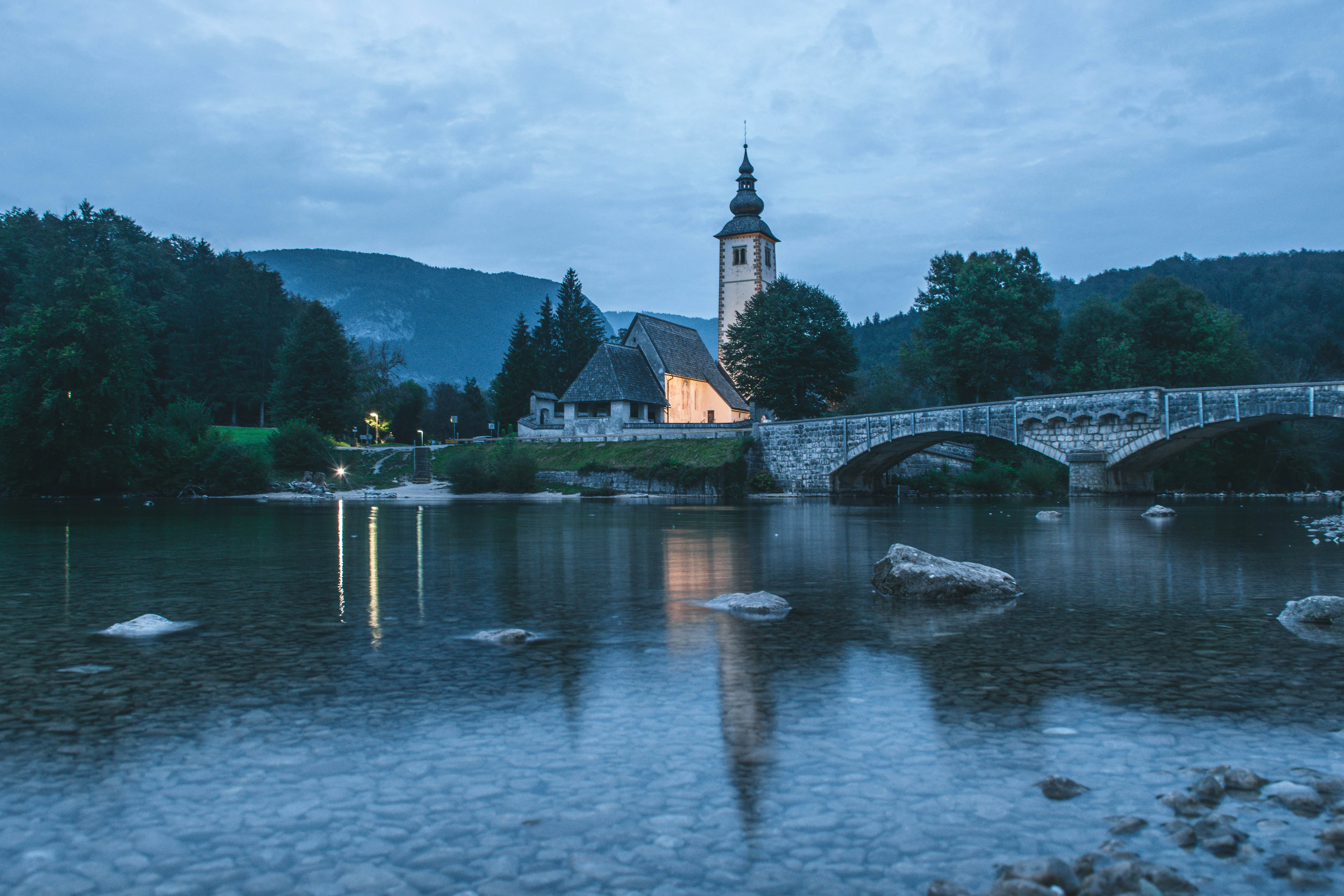 The church and stone bridge at Lake Bohinj in the evening